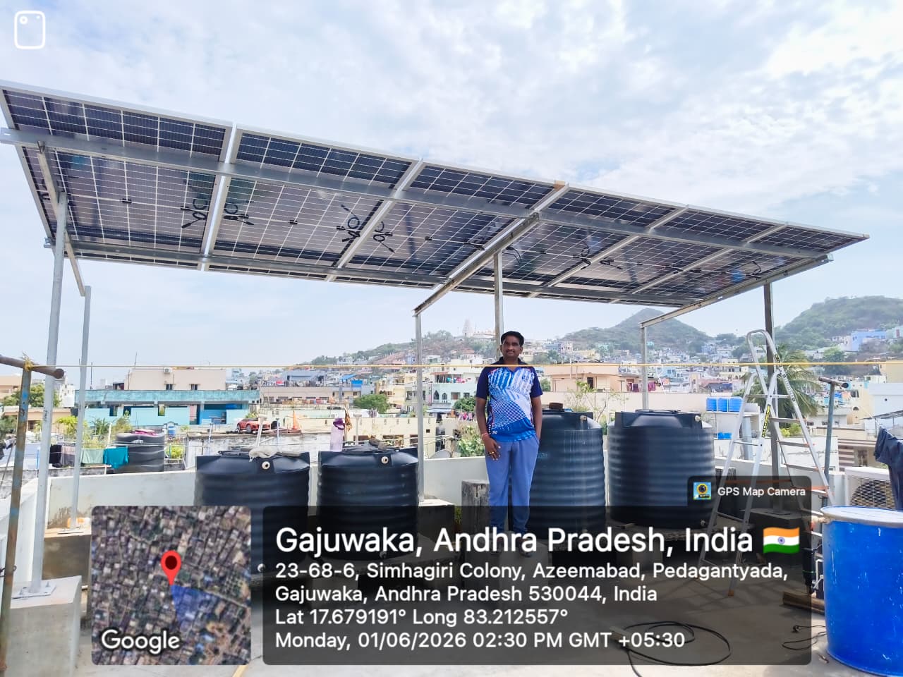Solar panel array installed on residential rooftop in Gajuwaka with water storage tanks and grid connection