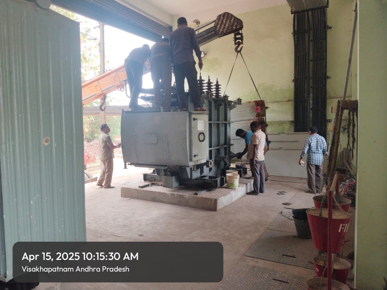Crew erecting a power transformer inside a substation building, dated April 15 2025, Visakhapatnam